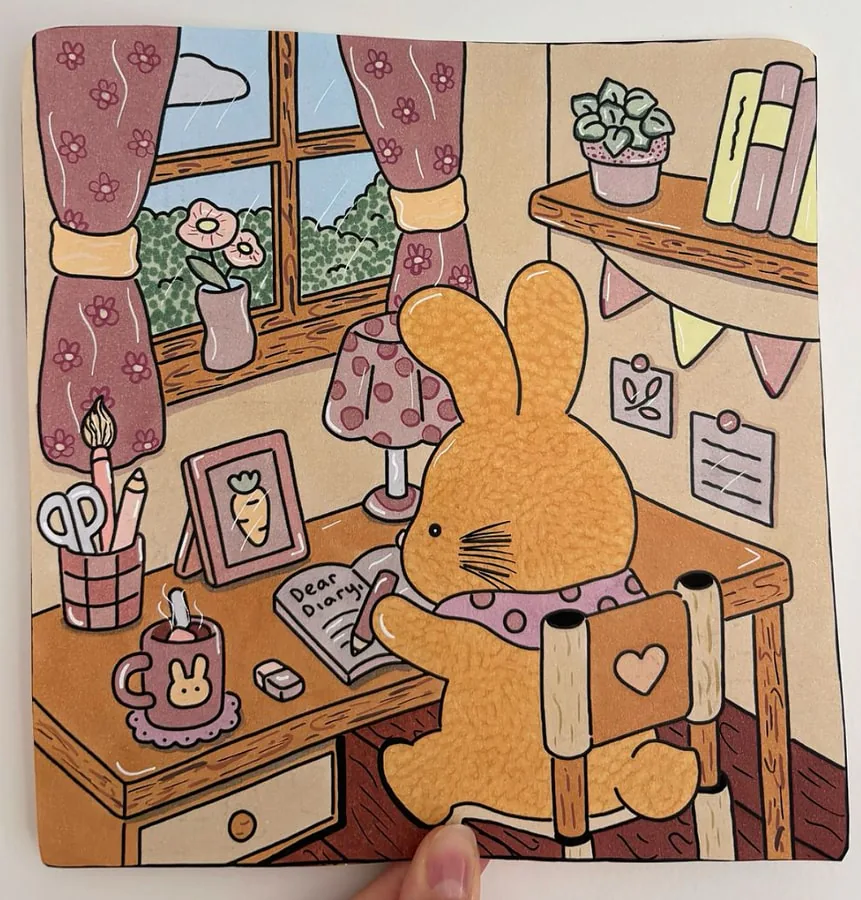 Coloriage cosy pastel avec un lapin qui écrit à son bureau, tons rose poudré et pêche